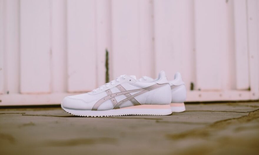 Stylish white sneakers set against a rustic wooden background, perfect for footwear fashion inspiration. - Photo by Hipkicks on Pexels