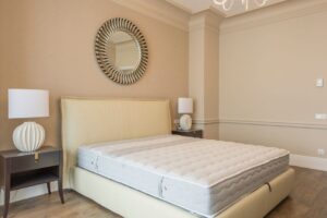 Spacious bedroom featuring modern decor, elegant lighting, and a plush bed with neutral tones. - Photo by Max Vakhtbovych on Pexels