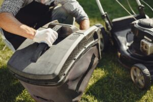 An adult man replacing a lawn mower bag on a sunny day in the yard. - Photo by Gustavo Fring on Pexels