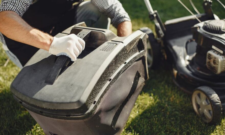 An adult man replacing a lawn mower bag on a sunny day in the yard. - Photo by Gustavo Fring on Pexels