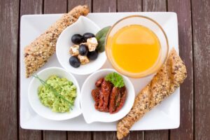 A delicious and nutritious breakfast featuring juice, bread, and fresh toppings on a white plate. - Photo by Pixabay on Pexels