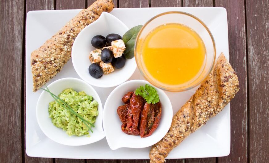 A delicious and nutritious breakfast featuring juice, bread, and fresh toppings on a white plate. - Photo by Pixabay on Pexels